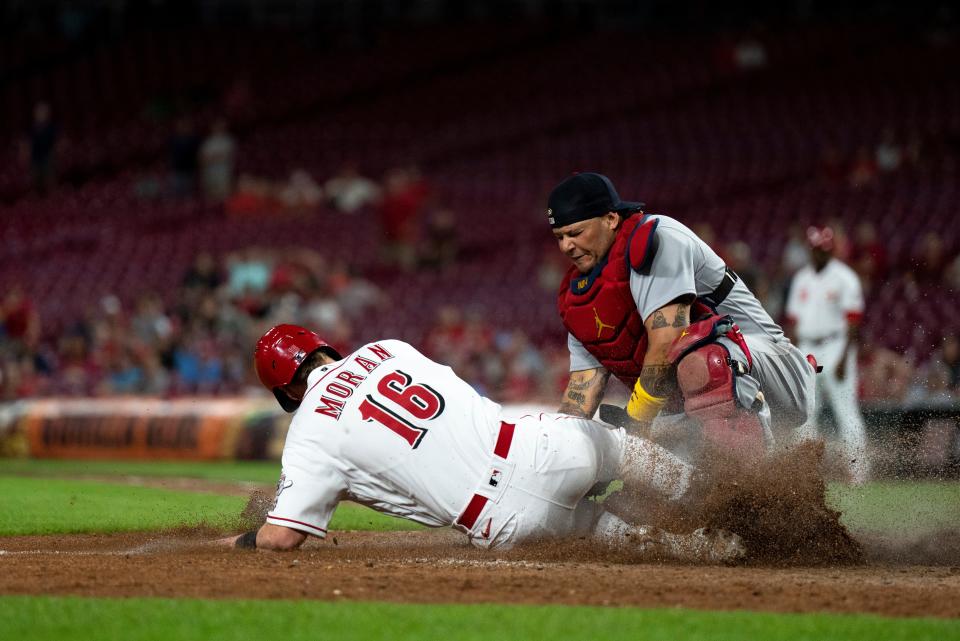 Cincinnati Reds first baseman Colin Moran (16) slides home as St. Louis Cardinals catcher Yadier Molina (4) tags him out with the score tied 2-2 in the eleventh inning of the MLB game between between the Cincinnati Reds and the St. Louis Cardinals at Great American Ball Park in Cincinnati, Wednesday, Aug. 31, 2022.