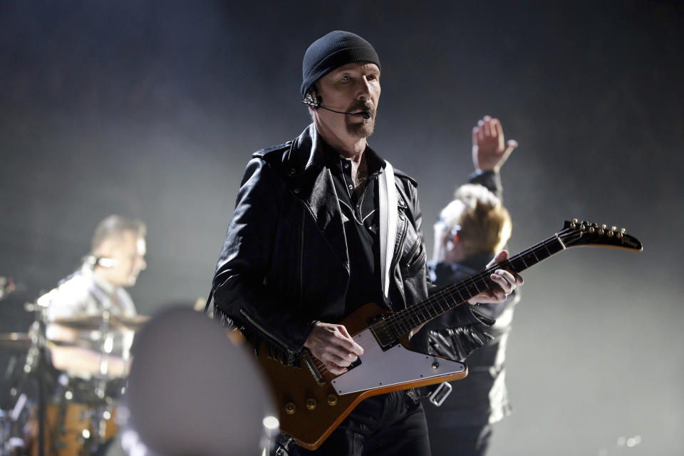 FILE - In this Sunday, Dec. 6, 2015, file photo, The Edge of U2 performs on stage during a concert, in Paris. A plan by U2 guitarist The Edge to build a cluster of mansions on a ridgeline above Malibu appears dead, after California's highest court declined to consider his last-ditch appeal. The musician, whose real name is David Evans, staged a 14-year legal fight to build five eco-friendly homes dubbed Leaves in the Wind in an undeveloped section of the Santa Monica Mountains west of Los Angeles. The state Supreme Court decided last week not to review a lower court ruling that denied approval to build on the land after the Sierra Club sued to block construction. (AP Photo/Thibault Camus, File)