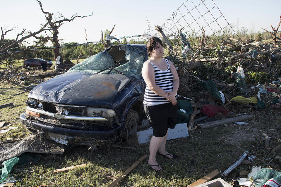 Woman standing by ruined vehicle