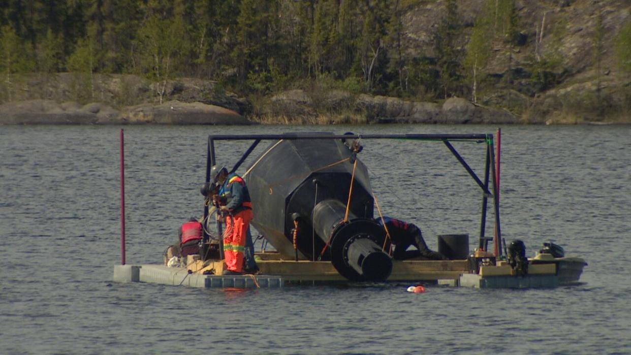 Workers install the aerator on Wednesday, June 5 in Yellowknife. (Robert Holden / CBC - image credit)