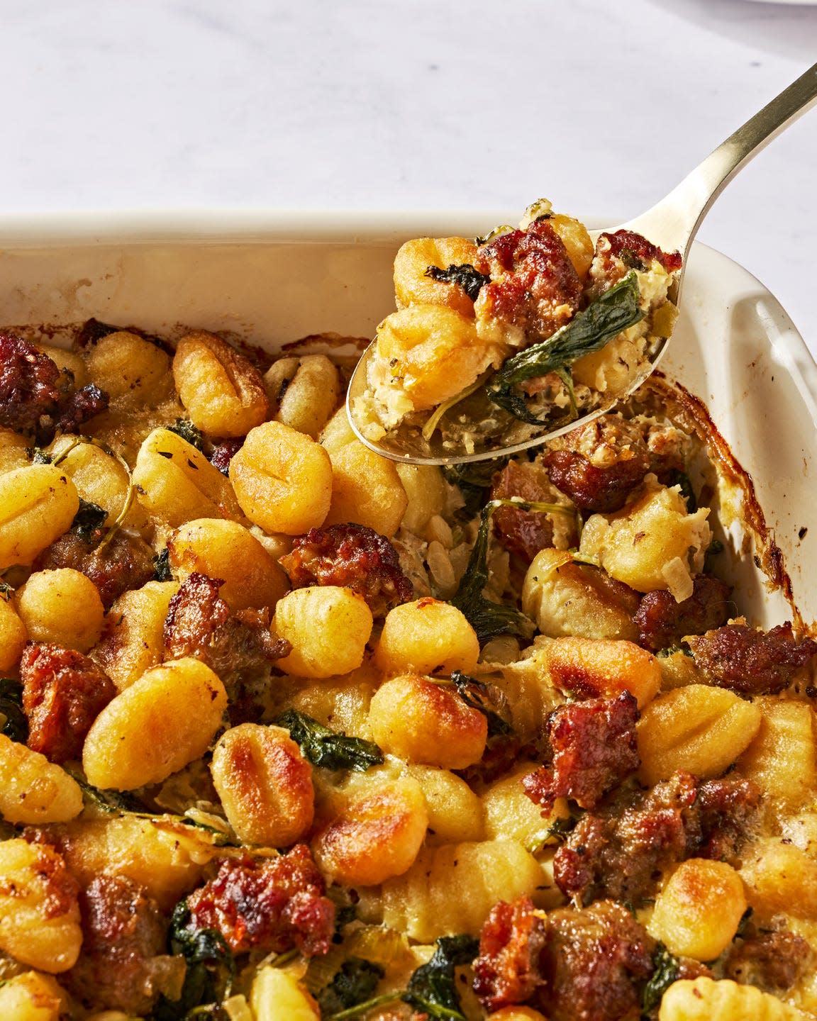 gnocchi and sausage stuffing in a white baking dish