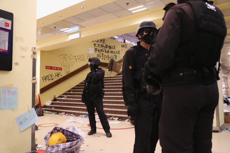 Members of a safety team established by police and local authorities look on as they assess and clear unsafe items at the Hong Kong Polytechnic University (PolyU) in Hong Kong, China