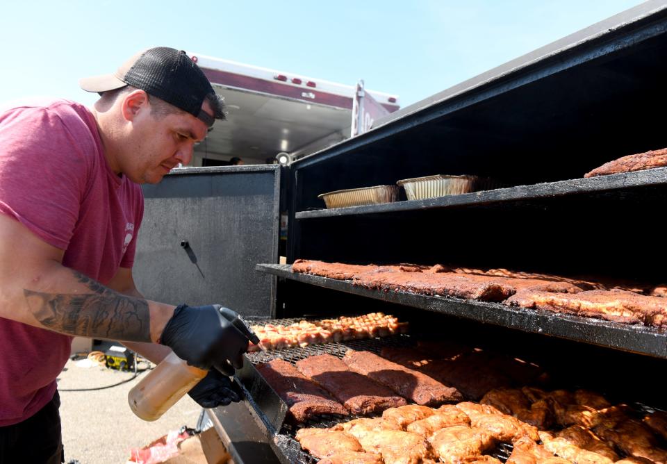 North Canton resedent Dave Wells with Uncle Bacon's BBQ works on the grill at the The Hall of Fame Ribs Burnoff. The 2024 event, which kicked off Friday, runs through Sunday on the grounds of the Pro Football Hall of Fame.