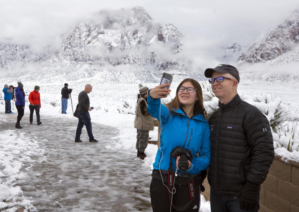 Libby McClellan, of the San Francisco Bay Area, takes a selfie with her father Kevin at the Red Rock Canyon National Conservation Area, west of Las Vegas, Thursday, Feb. 21, 2018. (Steve Marcus/Las Vegas Sun via AP)