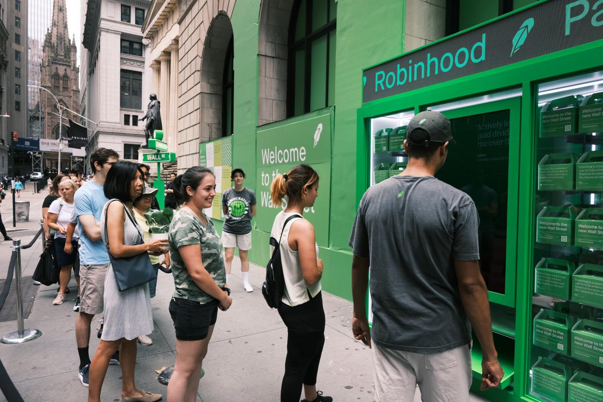 People wait in line for T-shirts at a pop-up kiosk for the online brokerage Robinhood along Wall Street after the company went public with an IPO  (Getty Images)