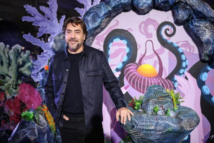 javier bardem standing next to an undersea prop at a little mermaid press event