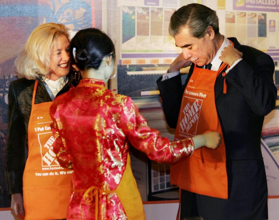 President of Home Depot's Asian and Canadian operations Annette Verschuren, left, looks at U.S. Commerce Secretary Carlos Gutierrez being fitted with an apron at a Home Depot, GE Aviation and VeriSign event announcing deals with Chinese companies during a ceremony at the Grand Hyatt hotel in Beijing, China, Wednesday, Dec. 13, 2006. U.S. retailer Home Depot Inc. signed an agreement Wednesday to buy a chain of Chinese home improvement stores. GE Aviation announced a jet engine sale. Also signed on Wednesday a deal between VeriSign and the China Netcom Group and the Ministry of Information and Industry. U.S. and Chinese companies announced deals ahead of a visit to Beijing by U.S. Treasury Secretary Henry Paulson for trade talks. (AP Photo/Elizabeth Dalziel) Canada