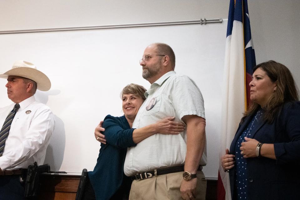 San Marcos police assistant Kelly Minor embraces Brian Frizzell, whose daughter Haley Frizzell died in the Iconic Village apartments fire, after his remarks during Thursday's announcement of an arrest made in the 2018 blaze.