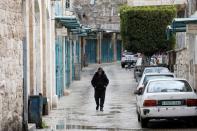 Man walks past closed shops as preventive measures are taken against the coronavirus, in Bethlehem in the Israeli-occupied West Bank