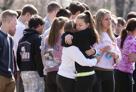 Students mourn in front of Jonathan Law High School in Milford, Connecticut April 25, 2014. REUTERS/Michelle McLoughlin