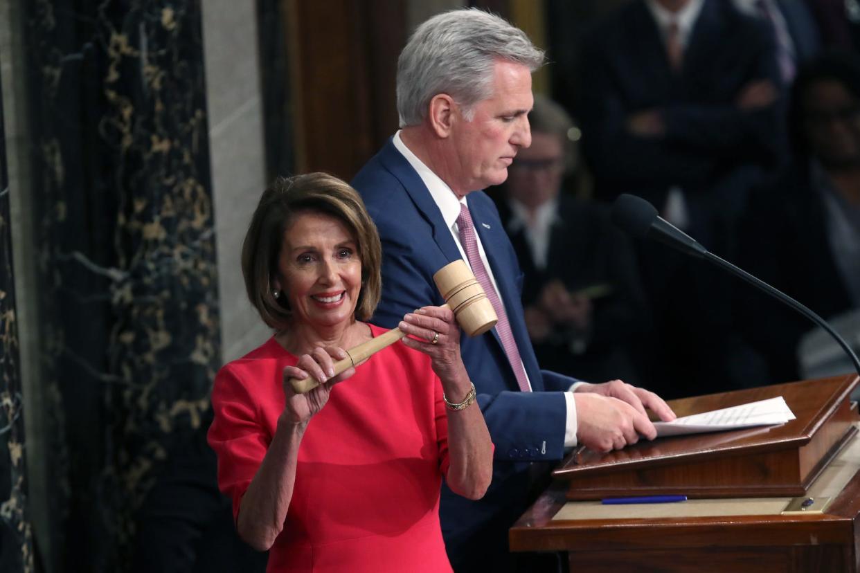 Speaker Nancy Pelosi holds up the leader's gavel while Minority Leader Kevin McCarthy addresses lawmakers during the opening session of the 116th Congress.