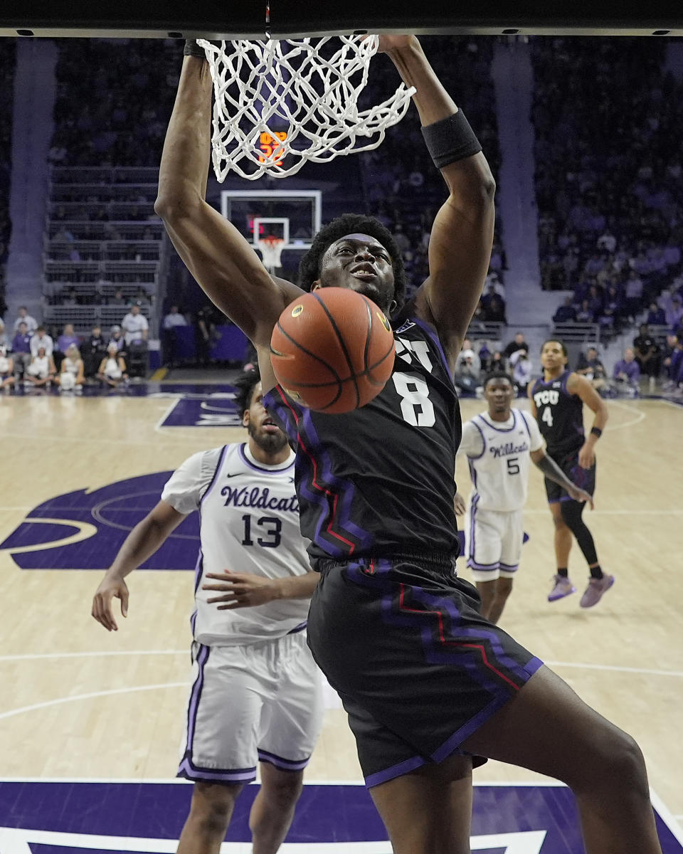 TCU center Ernest Udeh Jr. (8) gets past Kansas State forward Will McNair Jr. (13) to dunk the ball during the first half of an NCAA college basketball game Saturday, Feb. 17, 2024, in Manhattan, Kan. (AP Photo/Charlie Riedel)