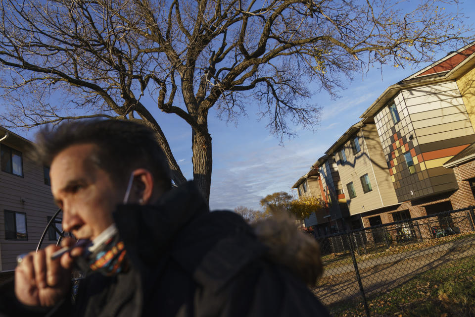 Greg Franson stands outside his apartment in Little Earth, a housing complex for Natives in Minneapolis, Monday, Nov. 15, 2021. An outreach worker for the Indian Health Board, he tried and failed to find recovery in mainstream treatment 10 times before he finally ended his addiction to opioids by reconnecting with his culture. (AP Photo/David Goldman)