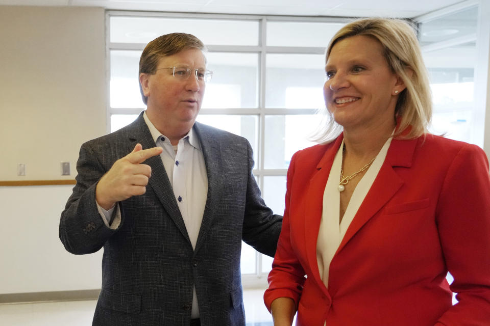 Mississippi Republican Gov. Tate Reeves, left, and his wife Elee Reeves, react to a reporter's question prior to voting at their Jackson, Miss., precinct, Tuesday, Nov. 7, 2023. Reeves, seeks reelection, and faces Democratic nominee Brandon Presley. (AP Photo/Rogelio V. Solis)