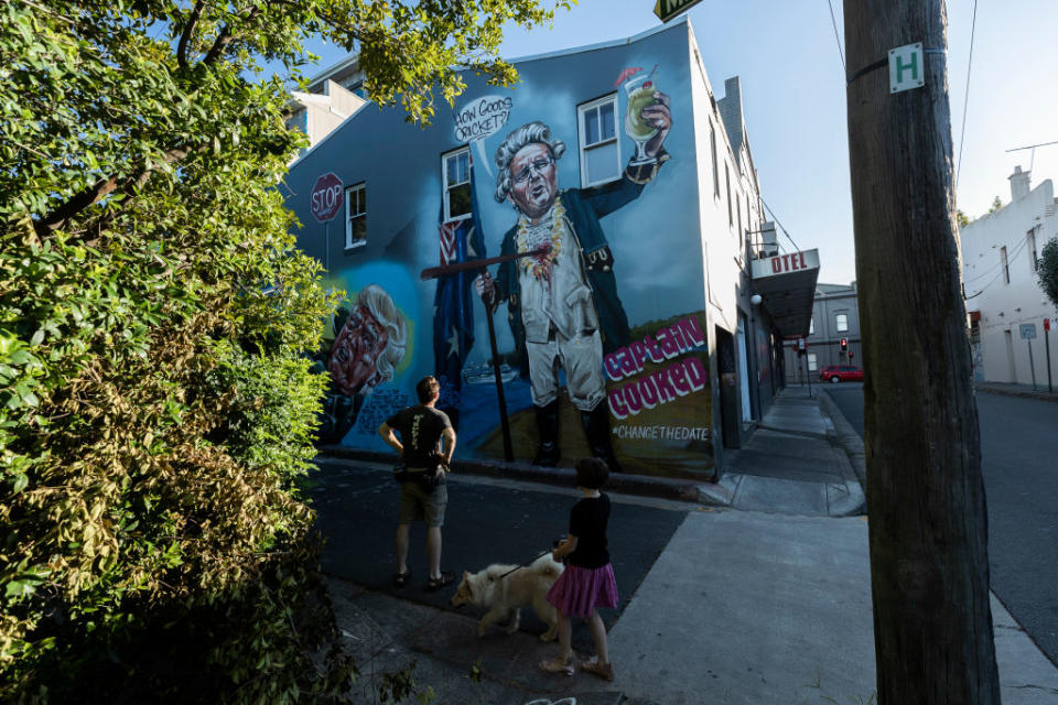 People look at a mural by street artist Scott Marsh in Newtown early on Australia Day. Source: Getty