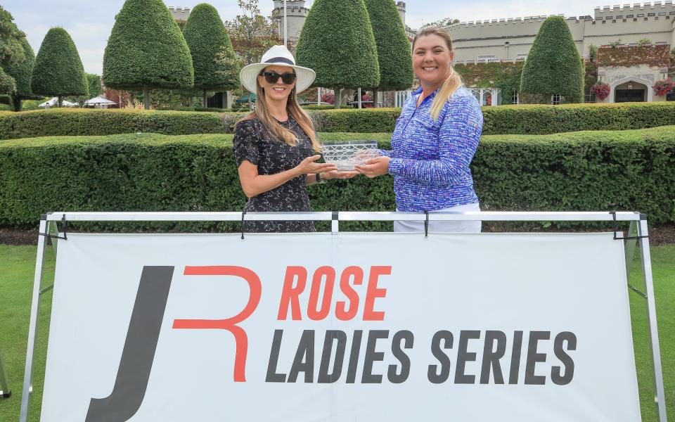 Alice Hewson of England is presented with the Rosebowl awarded to the winner of the Rose Ladies Series Grand Final by Kate Rose after the third round play in the Grand Final Series was abandoned due to the heath fire at Wentworth Golf Club on August 08, 2020 in Virginia Water, England.  - GETTY IMAGES