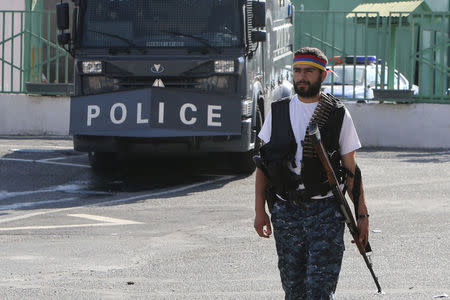 An armed man walks inside the Erebuni police station seized by "Sasna Tsrer" movement members in Yerevan, Armenia, July 23, 2016. REUTERS/Vahram Baghdasaryan/Photolure