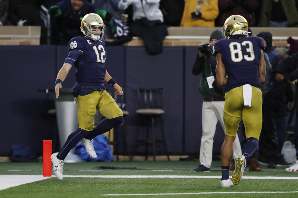 Notre Dame quarterback Ian Book (12) celebrates his 7-yard touchdown run with wide receiver Chase Claypool (83) during the second half of an NCAA college football game against Virginia Tech, Saturday, Nov. 2, 2019, in South Bend, Ind. (AP Photo/Carlos Osorio)