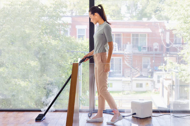 model using steam cleaner on floors