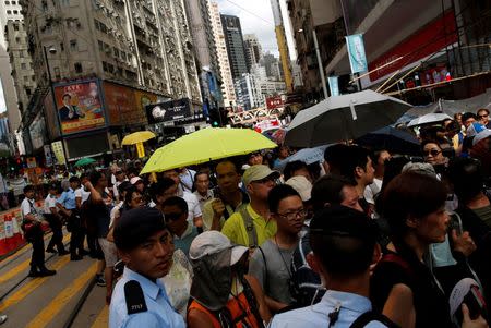 A protester carries a yellow umbrella, symbolizing the 2014 Occupy Central pro-democracy movement, during a protest march on the day marking the 19th anniversary of Hong Kong's handover to Chinese sovereignty from British rule, in Hong Kong, China July 1, 2016. REUTERS/Tyrone Siu