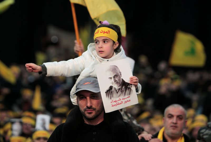 A girl holds a picture of Qassem Soleimani, head of the elite Quds Force, who was killed in an air strike at Baghdad airport, during a funeral ceremony rally to mourn his death, in Beirut's suburbs