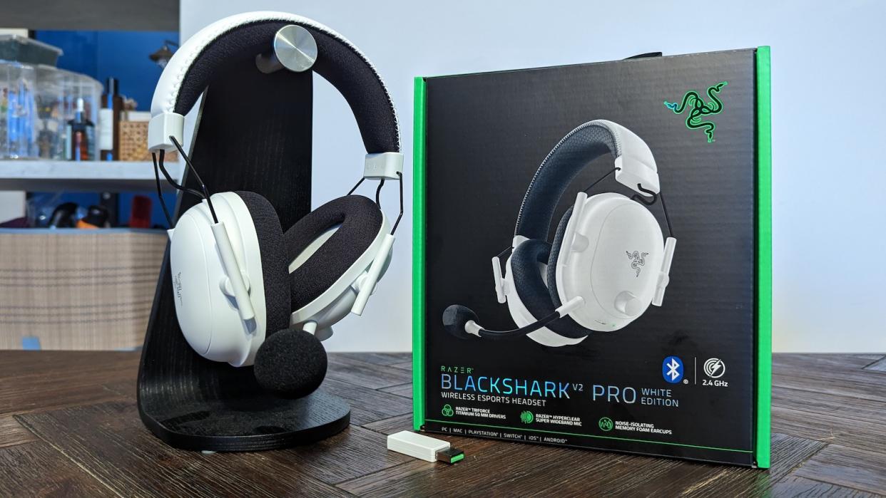The Razer Blackshark V2 Pro 2023 edition in white with its packaging on a wooden table.