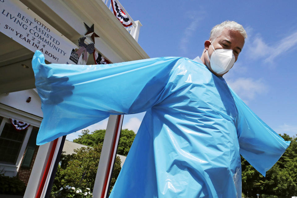 Williams demonstrates the lack of hand holes in a FEMA gown. Facilities are not using the items they received from the agency, he said. (Photo: ASSOCIATED PRESS)