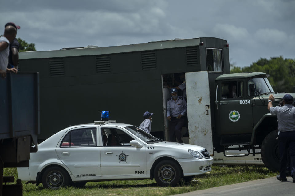 A police officer exits a police truck for transporting prisoners after detaining and placing demonstrators inside during a protest in Havana, Cuba, Sunday, July 11, 2021. Hundreds of demonstrators went out to the streets in several cities in Cuba to protest against ongoing food shortages and high prices of foodstuffs, amid the new coronavirus crisis. (AP Photo/Ramon Espinosa)