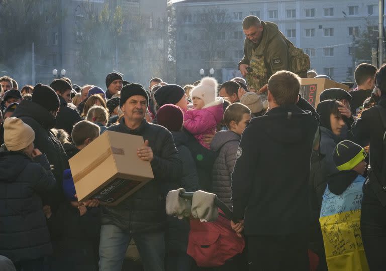 La gente recibe ayuda humanitaria en la plaza central de Kherson, Ucrania, el martes 15 de noviembre de 2022. 