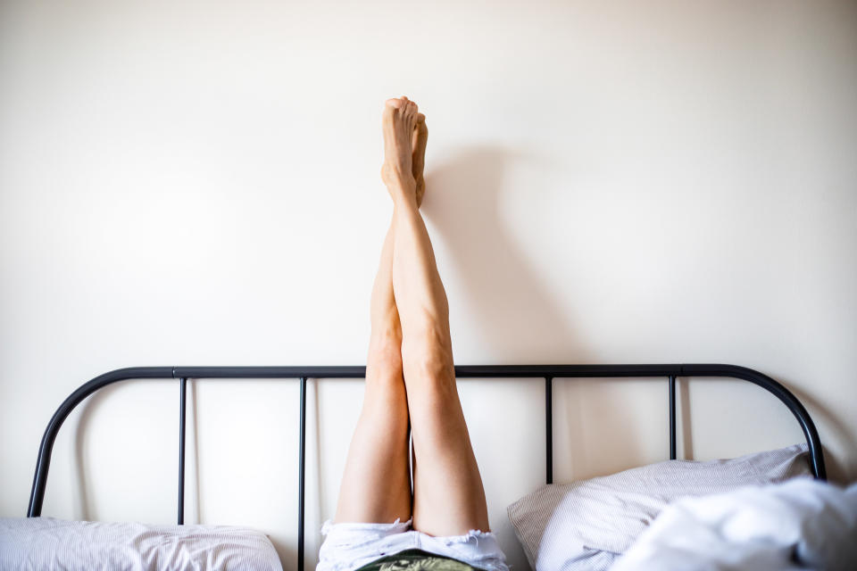 someone putting their feet by the headboard