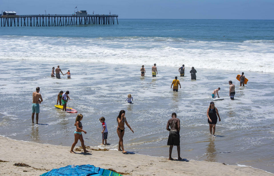 Un reducido número de bañistas disfrutan el mar al norte del muelle San Clemente en San Clemente, California, el sábado 4 de julio de 2020. (Mark Rightmire/The Orange County Register vía AP)