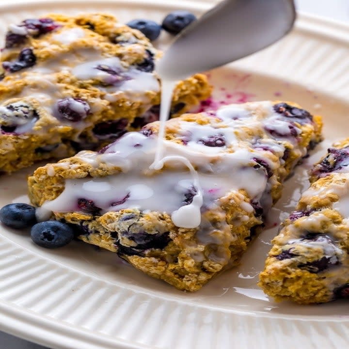 triangular blueberry scones with melted sugar being poured on top