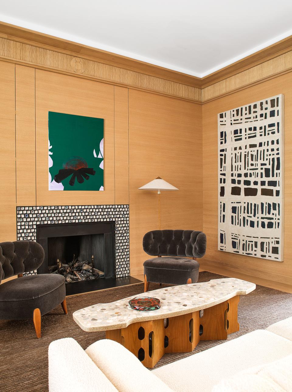 Otto Schulz chairs flank a ceramic mantelpiece by Armelle Benoit in the small living room. Paavo Tynell floor lamp; Harvey Probber table. On oak-paneled walls, art by Wilhelm Sasnal (left) and Valentin Carron.