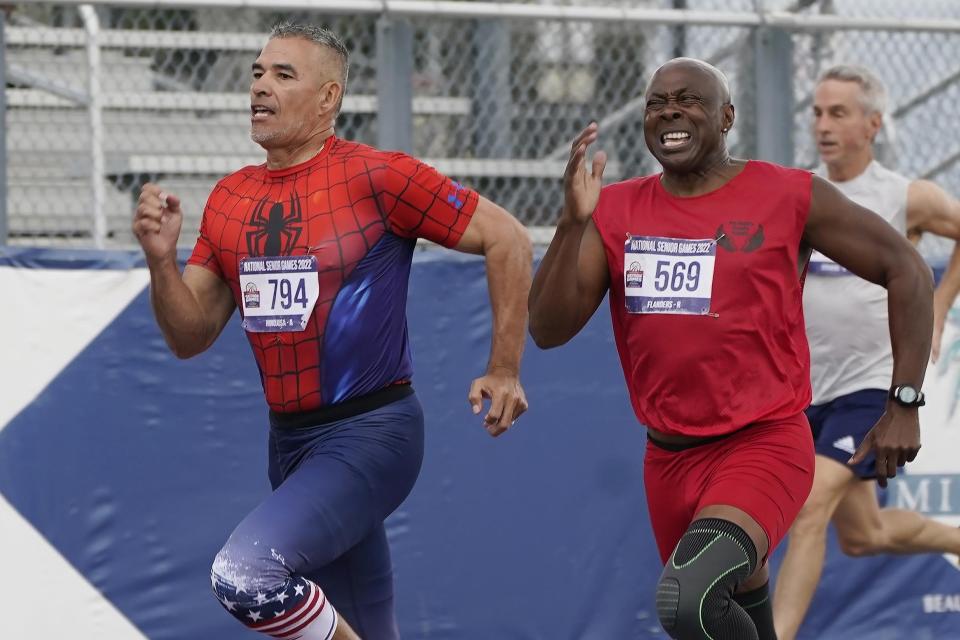 Anthony Hinojosa of California sprints to the finish line as Ronald Flanders of North Carolina, attempts to catch up during the final 200 meter race for men over 65 at the National Senior Games, Monday, May 16, 2022, in Miramar, Fla. (AP Photo/Marta Lavandier)