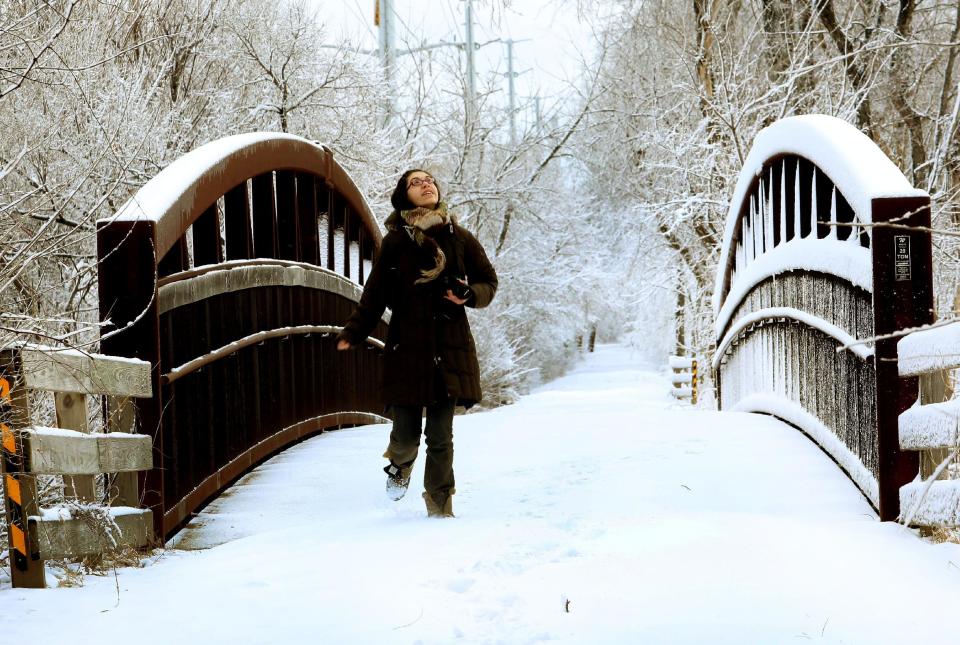 Wheaton Warrenville South High School senior Hannah Burns takes photos of the snow on the Prairie Path in Warrenville, Ill., after a winter storm on Wednesday, March 12, 2014. (AP Photo/Daily Herald, Bev Horne) MANDATORY CREDIT, MAGS OUT, TV OUT