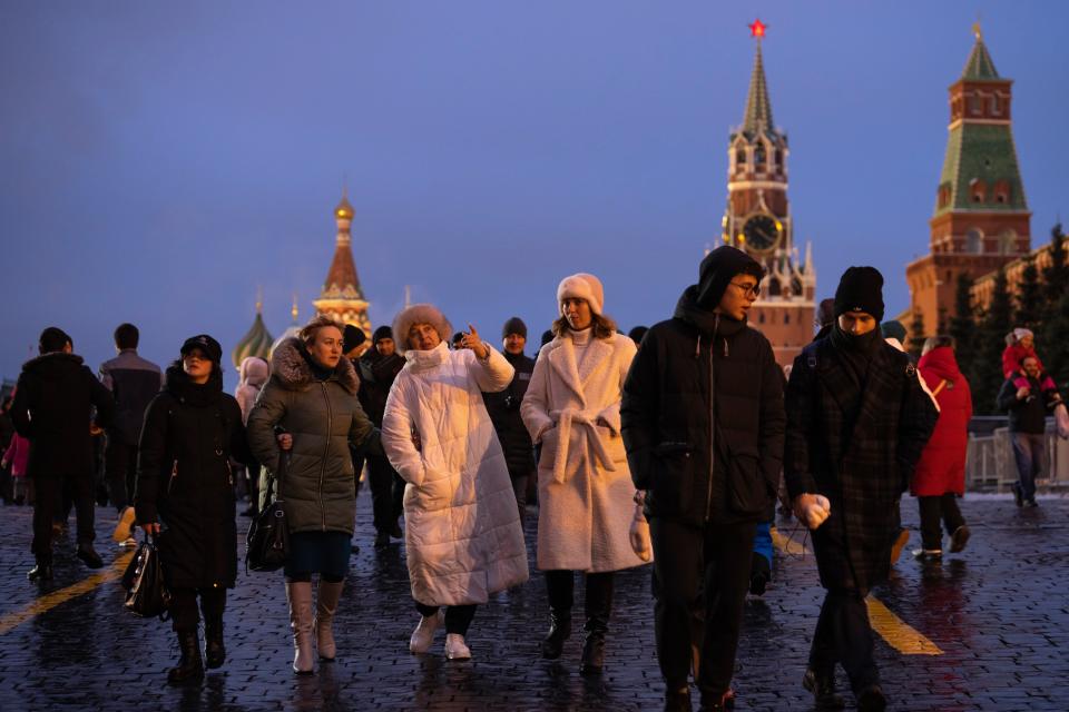 People walk in the Red Square prior to its closure for celebrations on the New Year's Eve (AP)