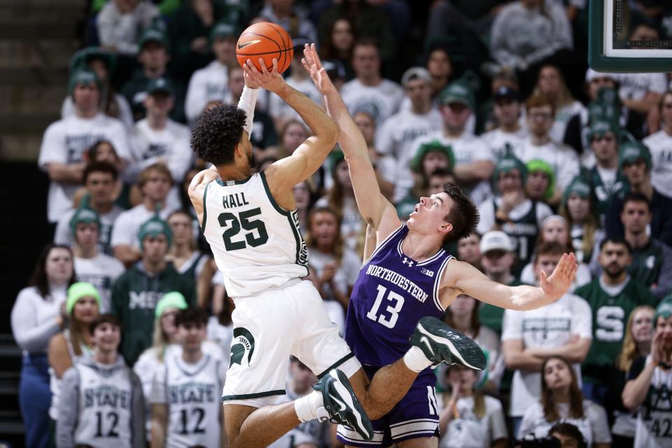 Michigan State forward Malik Hall (25), left, shoots against Northwestern guard Brooks Barnhizer (13) during the first half of an NCAA college basketball game, Wednesday, March 6, 2024, in East Lansing, Mich. (AP Photo/Al Goldis)