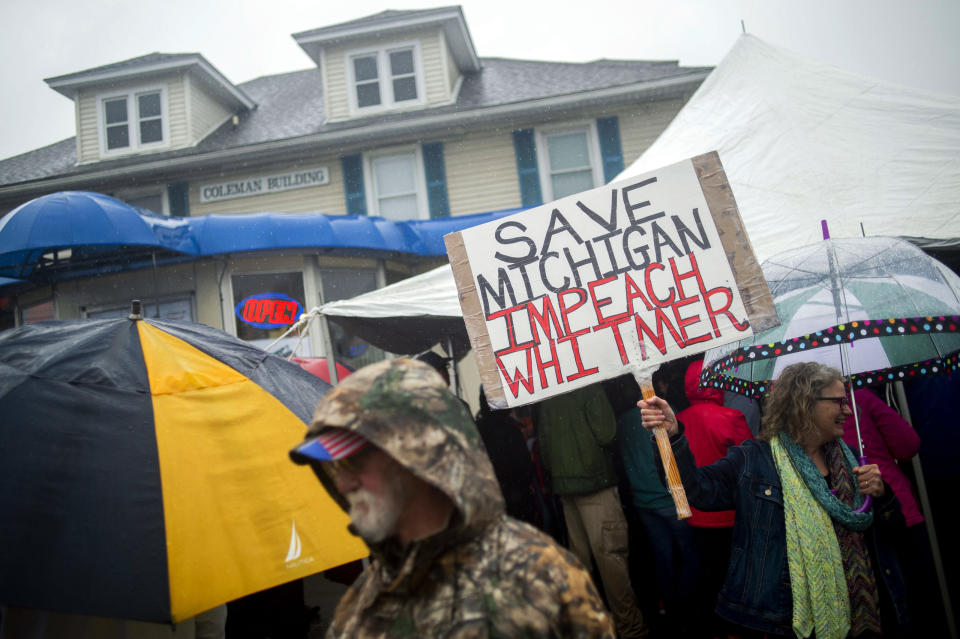 FILE - In this May 18, 2020, file photo, Michigan residents gather in protest of Gov. Gretchen Whitmer before a news conference featuring Texas hairstylist Shelley Luther, barber Karl Manke and others outside of Karl Manke's Barber and Beauty in Owosso, Mich. Manke's license was suspended last week by Michigan regulators for cutting hair in his shop. (Jake May/The Flint Journal via AP, File)