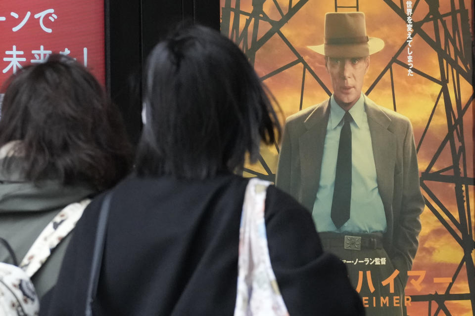 People walk in front of posters of films showing at a movie theater including the seven Academy Award winning movie "Oppenheimer" Friday, March 29, 2024, in Tokyo. “Oppenheimer” finally premiered Friday in the nation where two cities were obliterated 79 years ago by the nuclear weapons invented by the American scientist who was the subject of the Oscar-winning film. Japanese filmgoers' reactions understandably were mixed and highly emotional. (AP Photo/Eugene Hoshiko)