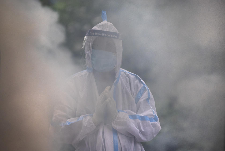 A relative performs final rituals before the cremation of a COVID-19 victim in Gauhati, India, Friday, July 2, 2021. India on Friday crossed the grim milestone of more than 400,000 people lost to the coronavirus, a number that though massive is still thought to be a vast undercount because of a lack of testing and reporting. (AP Photo/Anupam Nath)