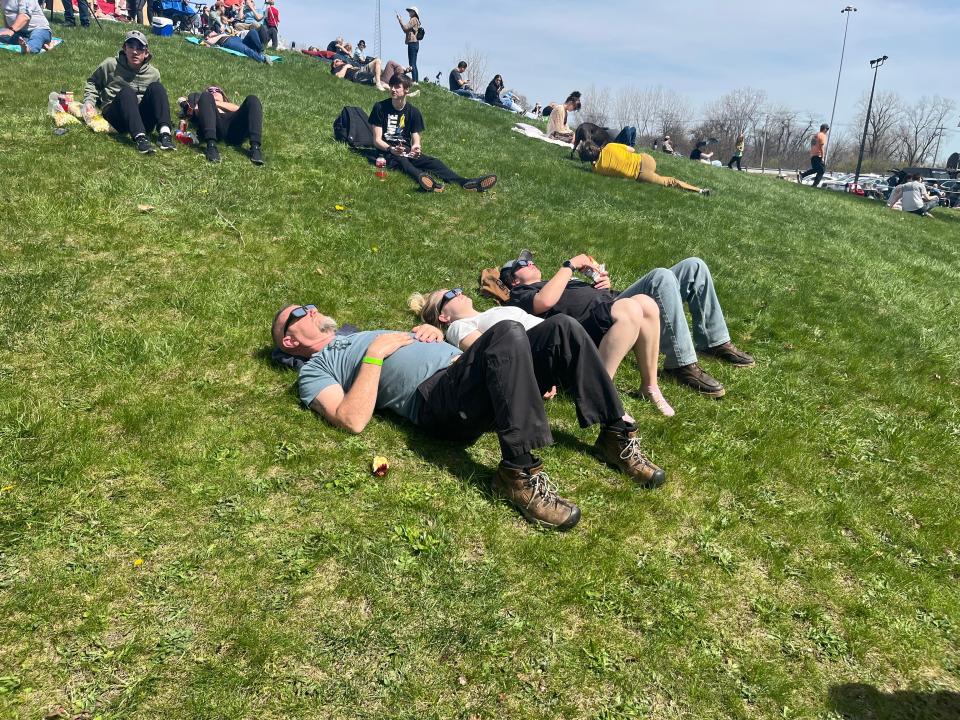 Eclipse-watchers lay on a hill in front of the Armstrong Air and Space Museum in Wapakoneta, Ohio, where the eclipse could be seen in totality for nearly four minutes, on April 8, 2024.