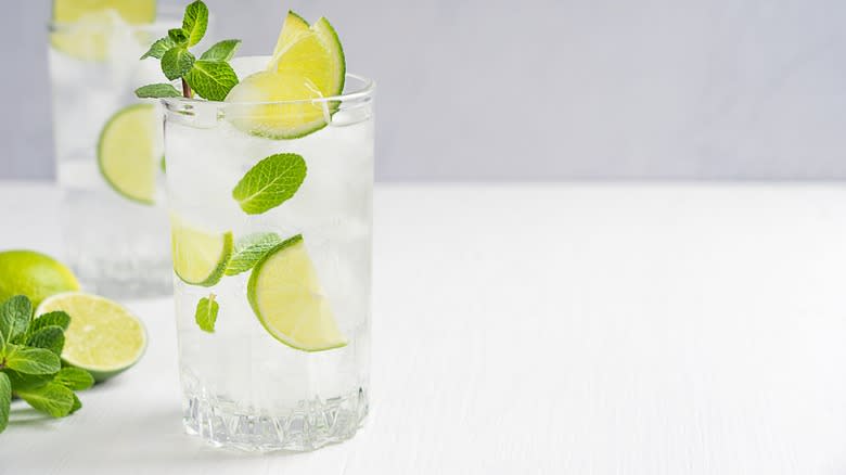 Cocktail with lime and mint garnishes