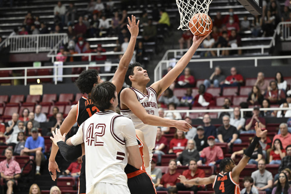 Stanford forward Brandon Angel, top right,lays up a basket past Stanford forward Maxime Raynaud (42) and Oregon State forward Michael Rataj, top left, during the second half of an NCAA college basketball game Saturday, Feb. 24, 2024, in Stanford, Calif. (AP Photo/Nic Coury)