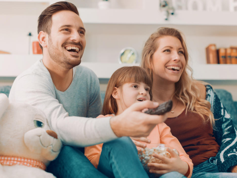 Eine junge Familie gemeinsam vor dem Fernseher (Bild: Ivanko80/Shutterstock.com)