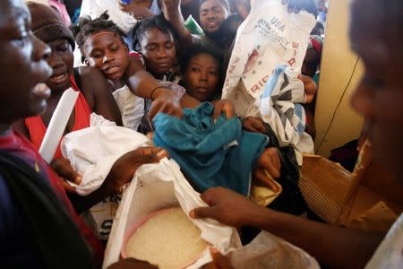 People try to get food during a special distribution in a church after Hurricane Matthew passed through Jeremie, Haiti, October 11, 2016. REUTERS/Carlos Garcia Rawlins