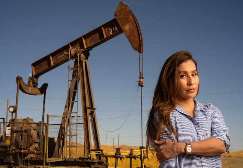 COALINGA CA SEPTEMBER 29, 2023 - Argelia Leon stands near an oil pumpjack in Coalinga. Images are for a commentary piece out of Coalinga about the oil industry's Levanta Tu Voz program, which is aimed at Latinos and raising questions about the transition from fossil fuels to renewable energy and electrification. (Tomas Ovalle / For The Times)