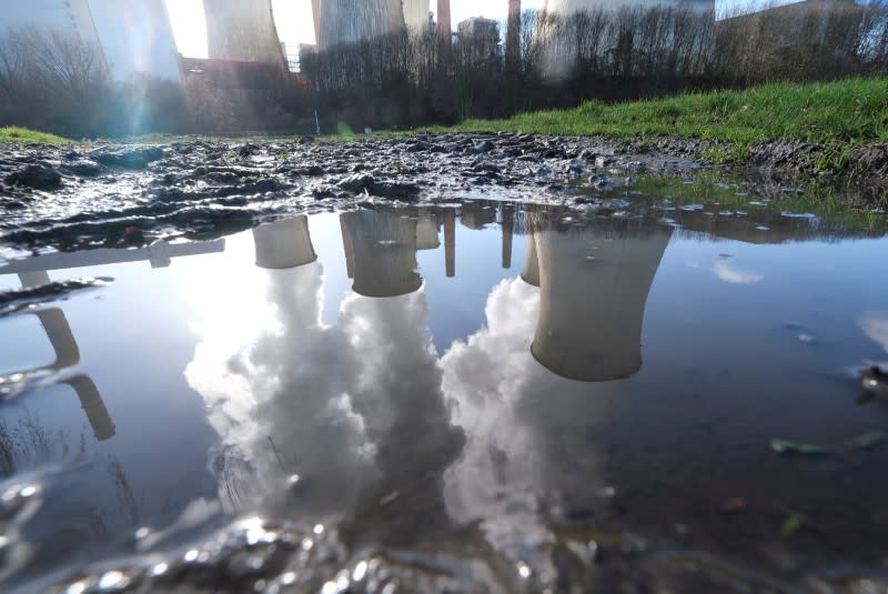 FILE PHOTO: The lignite power plant complex of German energy supplier and utility RWE is reflected in a puddle in Neurath