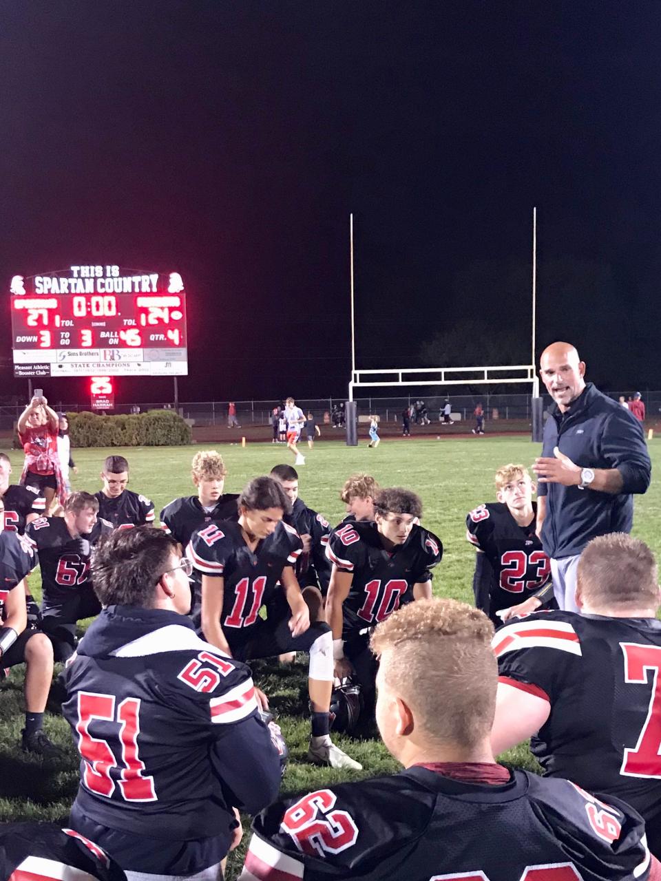 Pleasant head football coach Kevin Kline talks to his team following it's last-minute 27-24 victory over Marion Harding Friday night at home. It was his first victory at PHS.