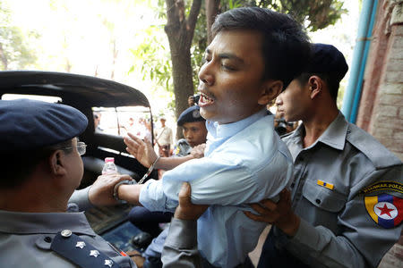 Detained Reuters journalist Kyaw Soe Oo is escorted by police before a court hearing in Yangon, Myanmar April 11, 2018. REUTERS/Ann Wang