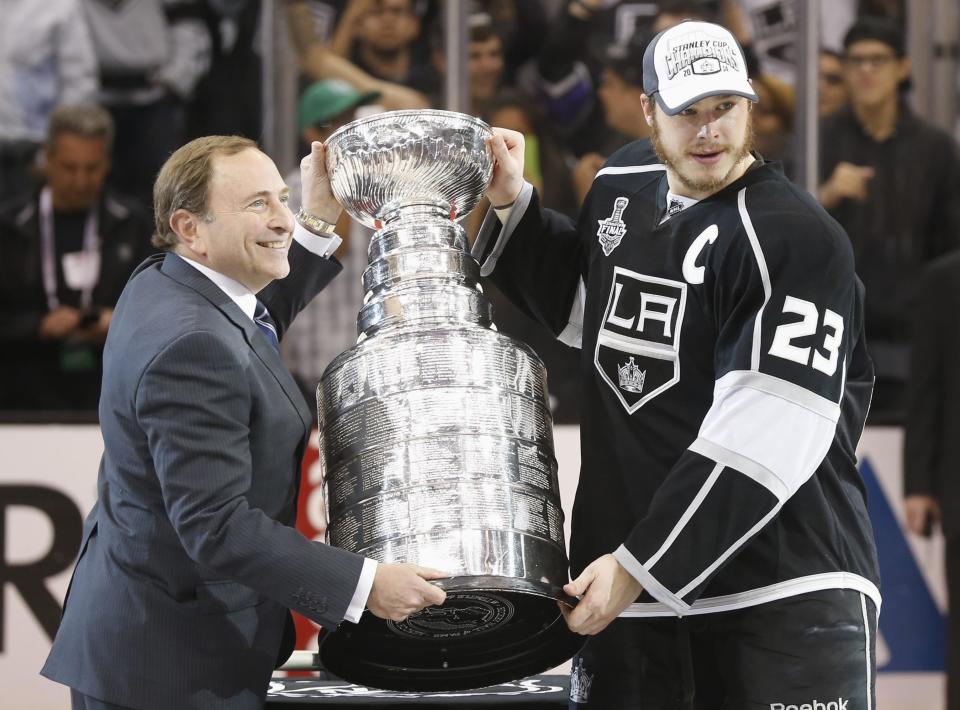 Los Angeles Kings' Dustin Brown (R) is presented with the Stanley Cup after the Kings' defeated the New York Rangers in Game 5 of their NHL Stanley Cup Finals hockey series in Los Angeles, California, June 13, 2014. REUTERS/Lucy Nicholson (UNITED STATES - Tags: SPORT ICE HOCKEY)